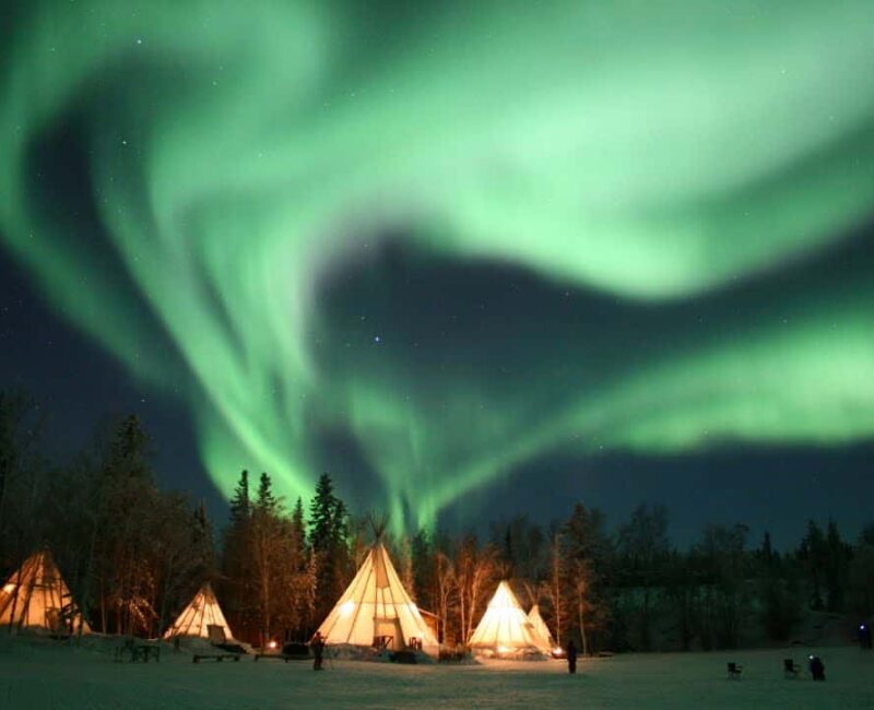 Aurora-Village-Yellowknife-Northwest-Territories-Canada-Aurora-Borealis-Northern-Lights-winter-Landscape-Colourful-Green-five-Teepees-Hero